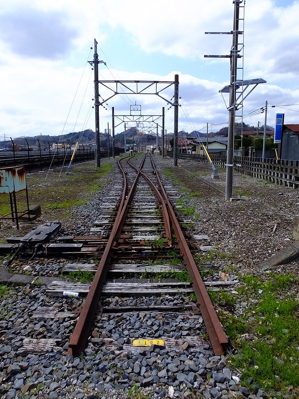 葛生駅の北には、軌道の痕跡がいまもあり、石灰石などを運ぶ列車が行き来した会沢線、大叶線、日鉄鉱業専用線などの線路を想像できる。当時の貨物線のレール脇にある工場には、役目を終えた貨車の姿もある