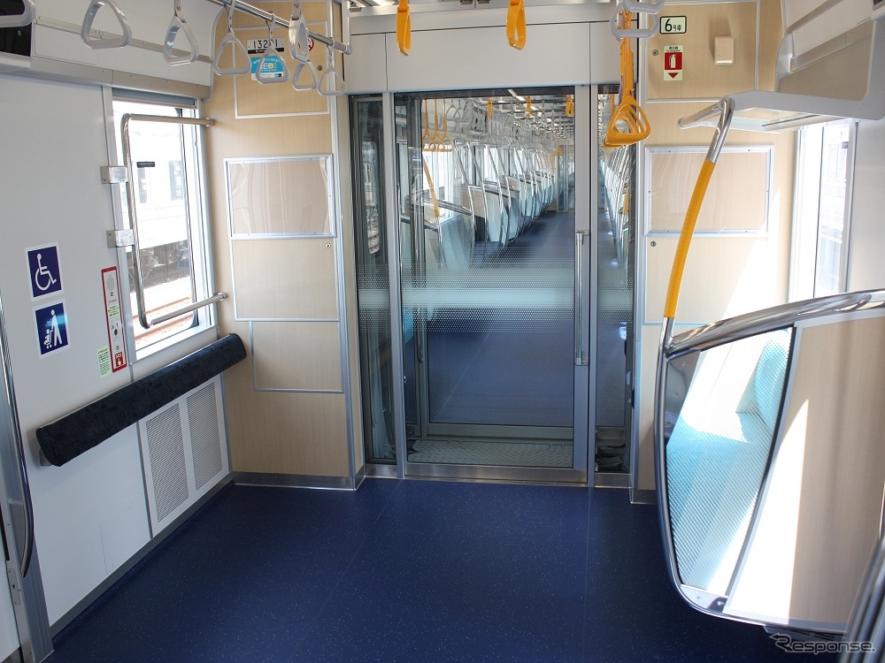 フリースペース（左）は全ての車両に設置。連結部の大型ドアもガラスを使用している。