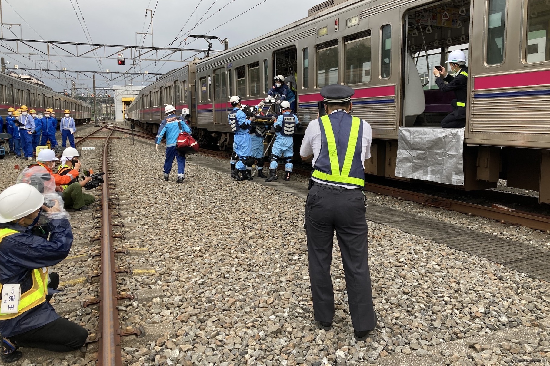京王電鉄・総合事故復旧訓練：重傷者の搬送。写真中央、背中の人物はバディコムを使用中だ。