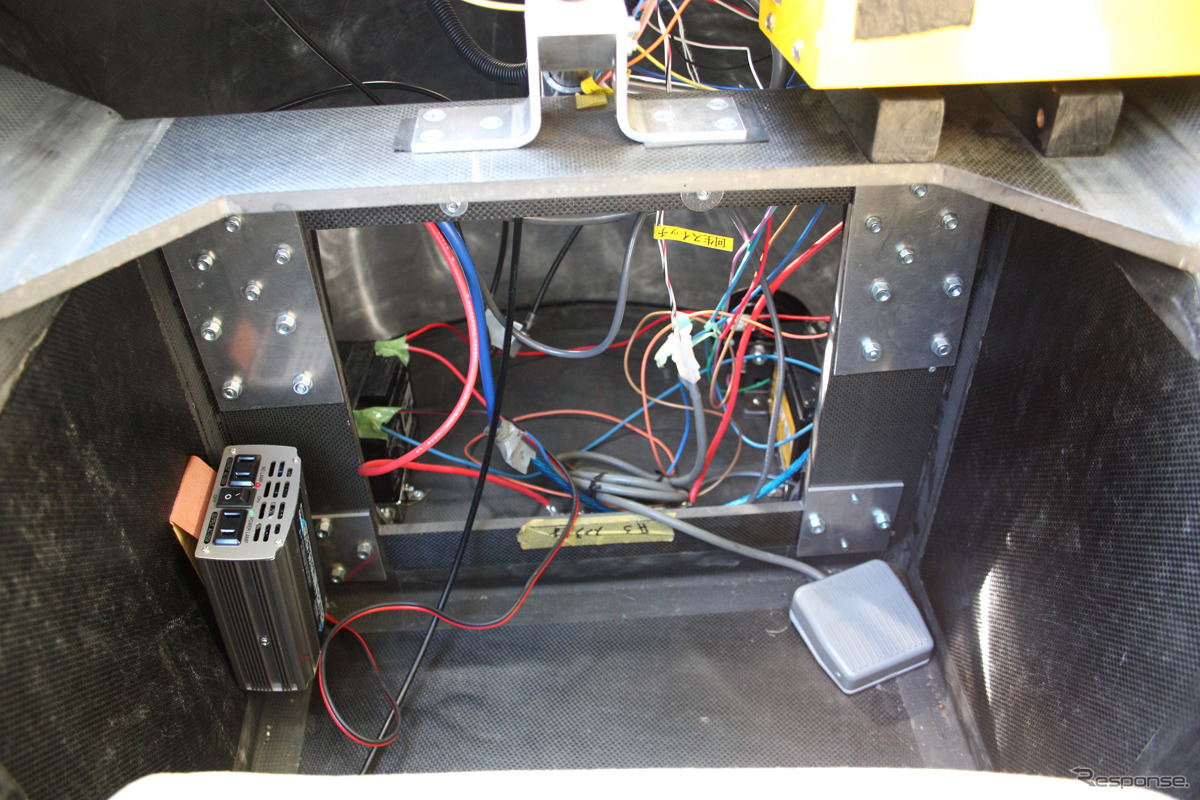 ペダルはない。右の小さい箱は回生ブレーキの制御ユニット。コンセントは情報機器の充電に使用。