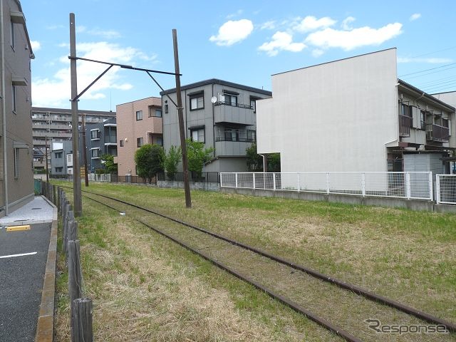 新宿線南大塚駅付近に残る赤さびたレールと木製の架線柱は、川砂利輸送を目的に建設された安比奈線の名残。法手続上は現在も休止であり、「廃線」ではない。