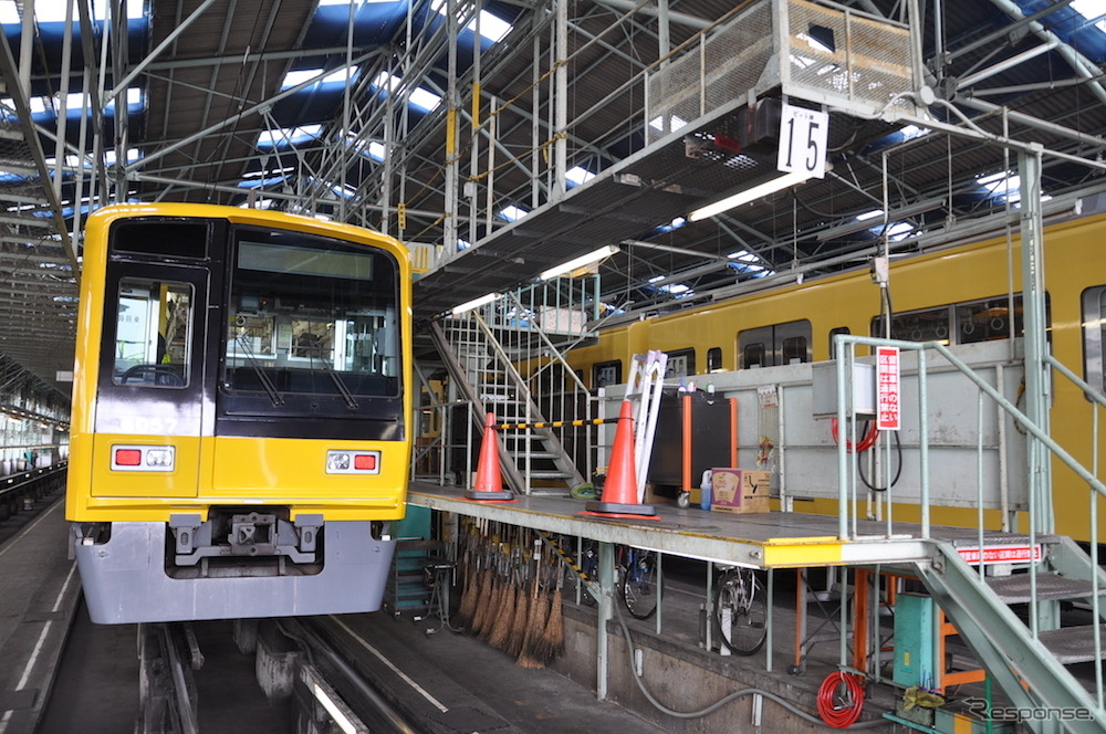 西武鉄道は4月18日から運行を開始する「黄色い6000系電車」のラッピング作業を公開した。黄色い電車の2000系（右）と並ぶラッピング車の6000系