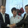 溝畑宏観光庁長官（左）らと握手する小林可夢偉（中央）