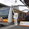 南武線の新型車両E233系が10月4日、営業運転を開始。一番列車に出発合図を送る武蔵中原駅の芹澤駅長