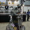 こちらのロボットは実際に操作できる。マンマシンシナジーエフェクタ（人間機械相乗効果器）を提唱する金岡克弥博士による展示。