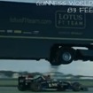 走行するロータスF1マシンの上をルノーの大型トレーラーが飛び越える