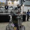 こちらのロボットは実際に操作できる。マンマシンシナジーエフェクタ（人間機械相乗効果器）を提唱する金岡克弥博士による展示。