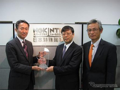 トムソン・ロイターの日本法人 代表取締役・冨井俊行氏（左）からトロフィーを授与するNGK大島崇文副社長（中央）および青木昇知的財産部長（右）
