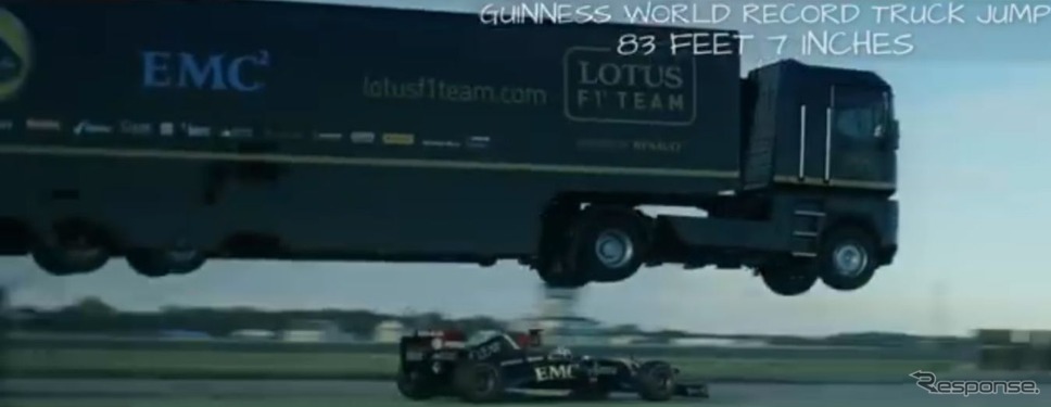 走行するロータスF1マシンの上をルノーの大型トレーラーが飛び越える