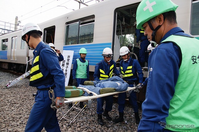 列車内の負傷者は多人数で搬出していく。