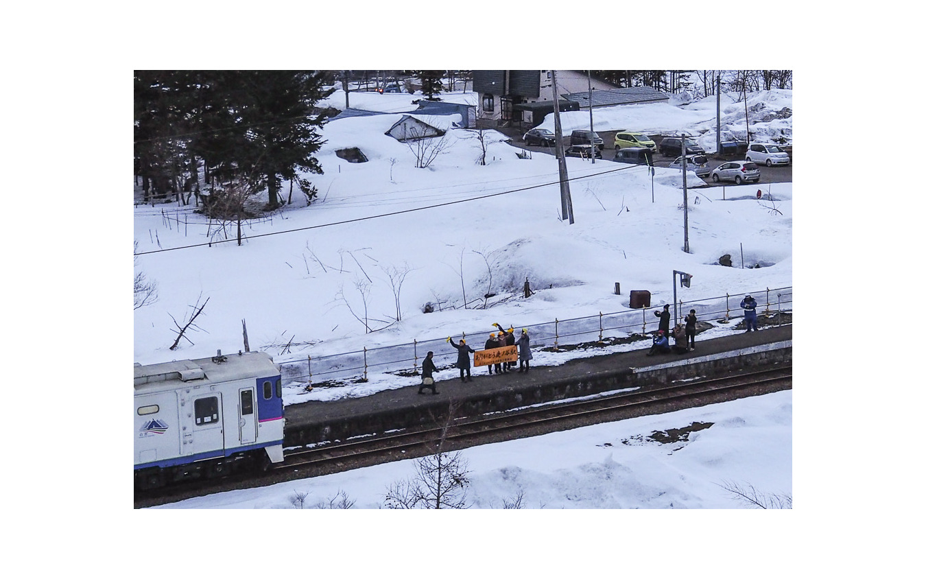 鹿ノ谷駅で横断幕を掲げ、新夕張行きの発車を見送る地元の人々。2019年3月31日撮影。