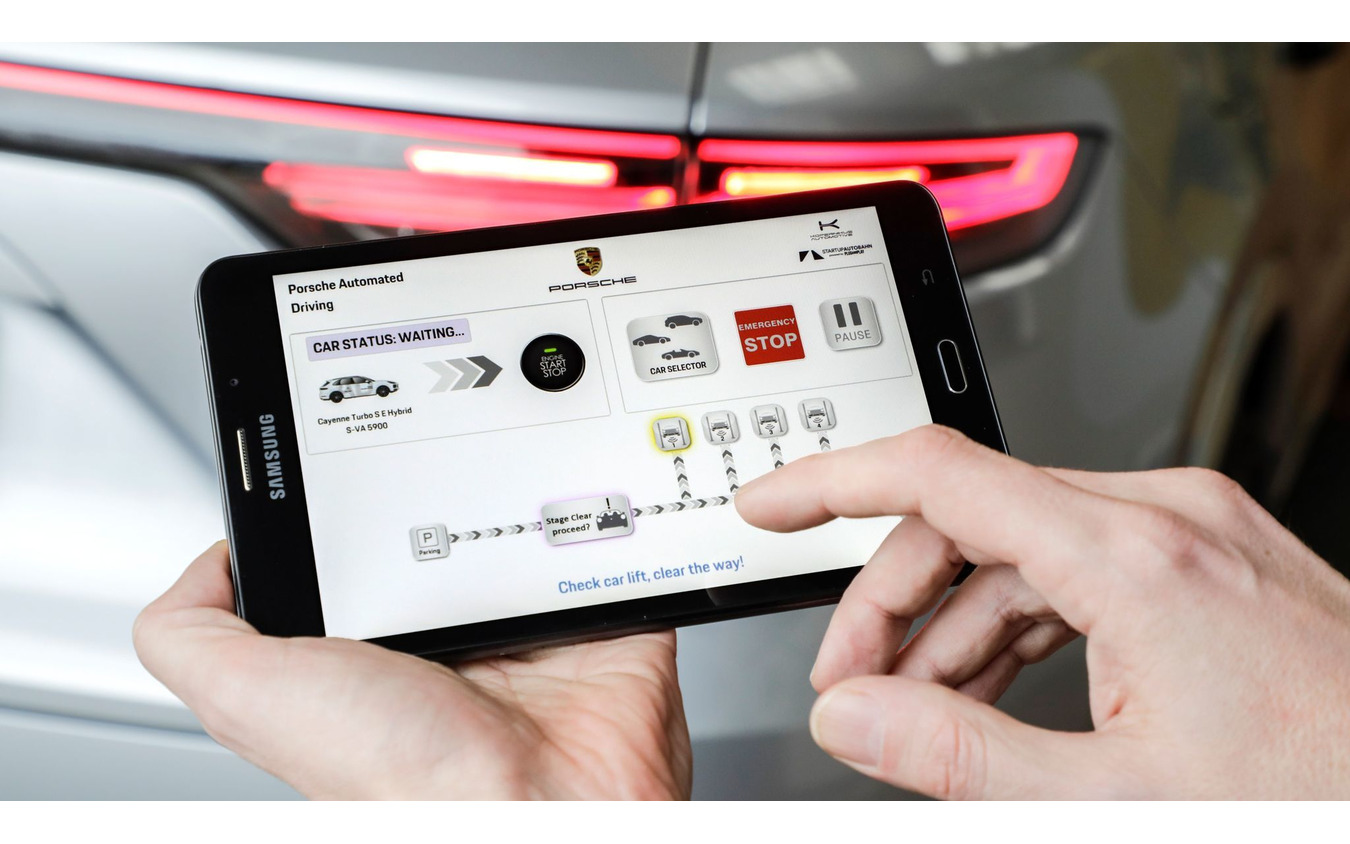 ポルシェ自動運転システム。メカニックはタブレット端末を使用して、カイエンを修理工場内の所定位置に、すばやく自動運転でピットインさせる