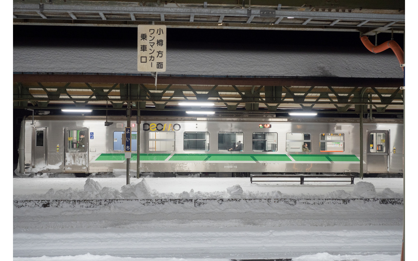 夜の余市駅で発車を待つ小樽行き普通列車。余市～小樽間は輸送密度が2000人/日を超えるものの、深夜の下り列車は1両でも閑散としている。2022年1月2日。