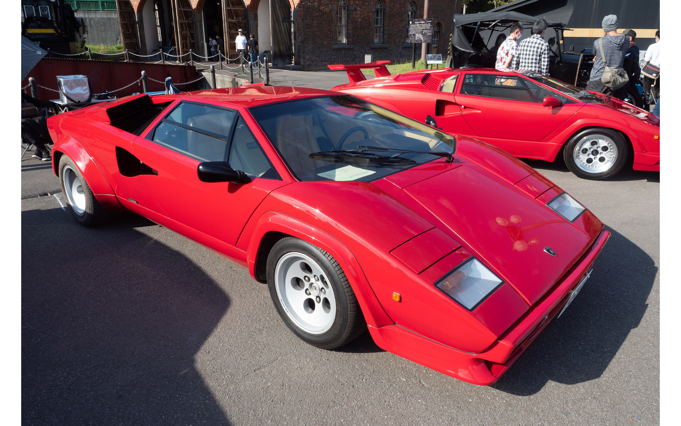 「T型フォード」と並ぶ形で2台が鎮座する赤い『カウンタック』。奥が25周年のアニバーサリーモデル（1989年）。