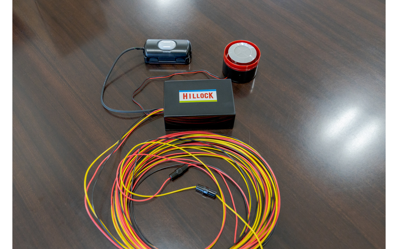 左上がブザー音停止スイッチ、右上がスピーカー。真ん中の黒いボックスは制御ユニット。黄、黒、赤の配線は電源に繋ぐためのもの。