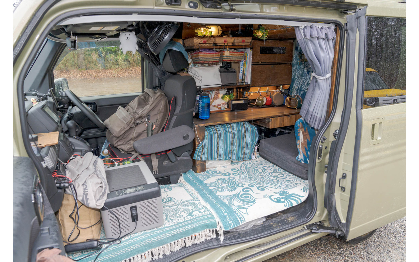 車体の半分をテーブルを含めた家具で占める。手前は座るスペースと寝るスペースを兼用。