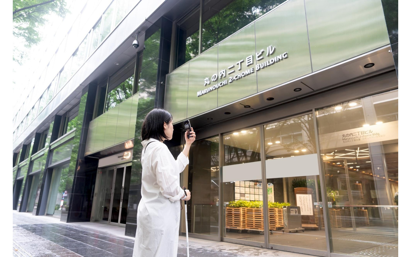 AI画像認識機能を用いて建物を確認している女性。写真の画像を音声で説明してくれる