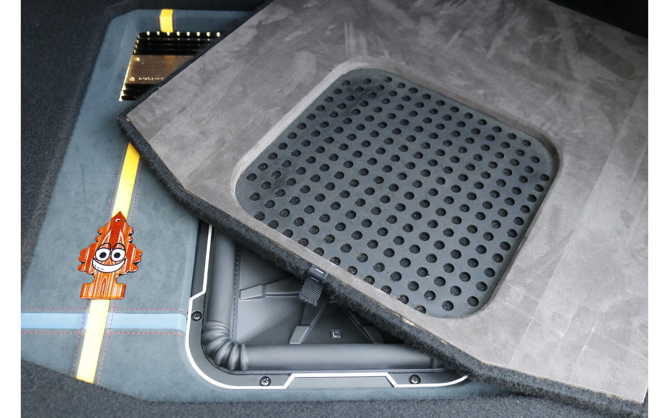 ラゲッジの中央部をカバーするプロテクションボードはサブウーファー部分に音抜け用の処理が施されている。