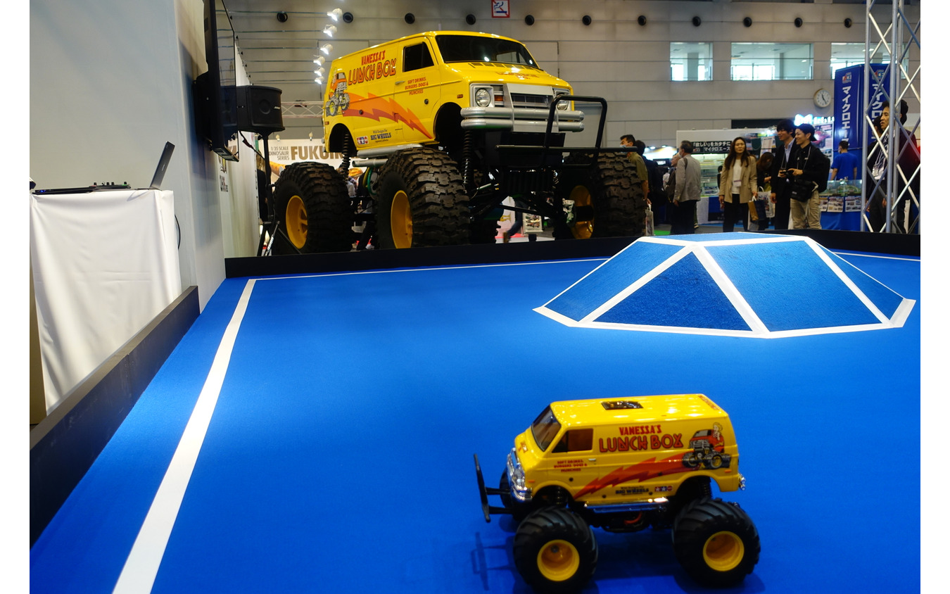 タミヤのランチボックスRCカー。背景に移るのはホンモノのクルマ。