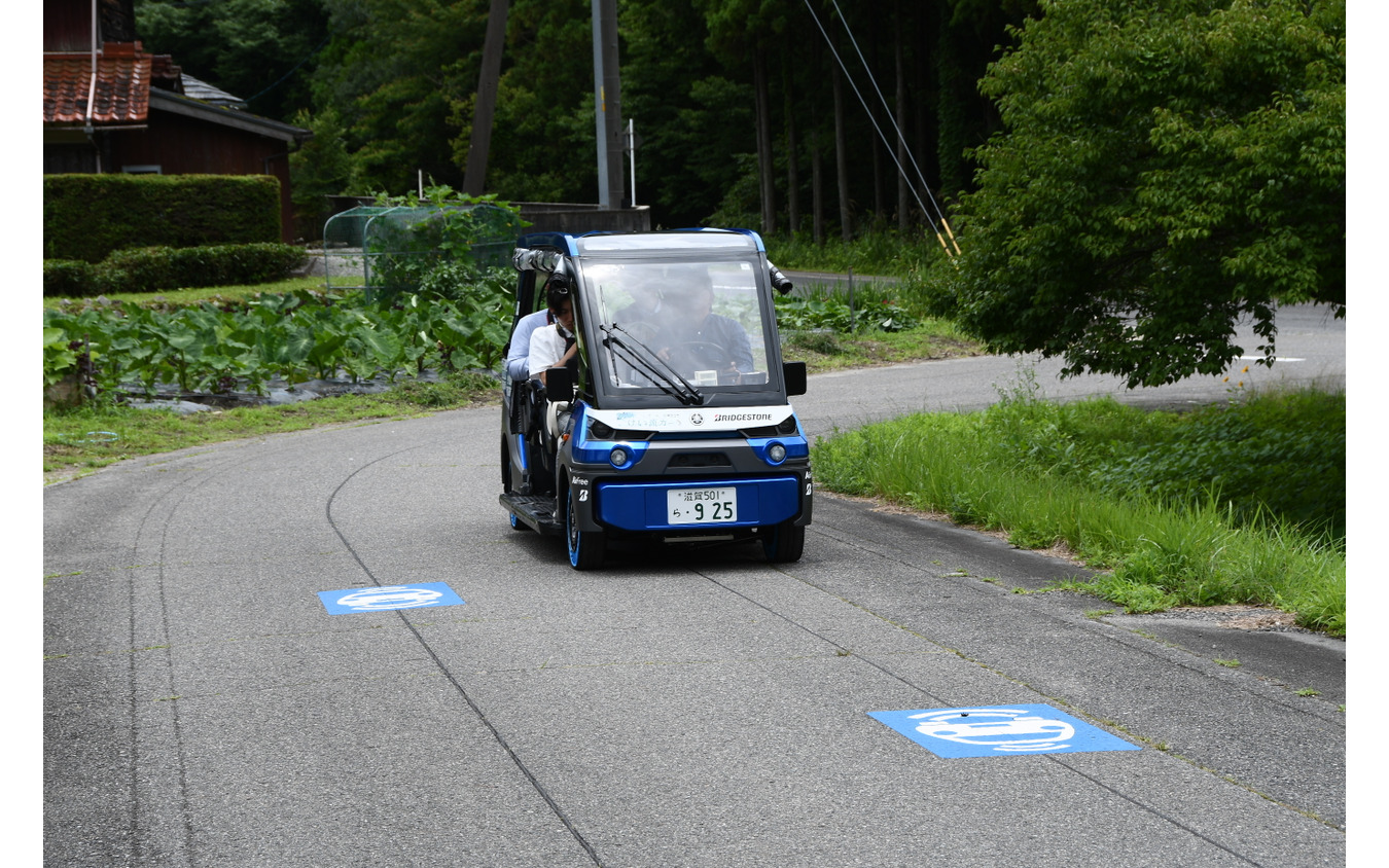 市道を走る「奥永源寺けい流カー」。道路上の黒い線が自動運転を制御するために敷設された電磁誘導線