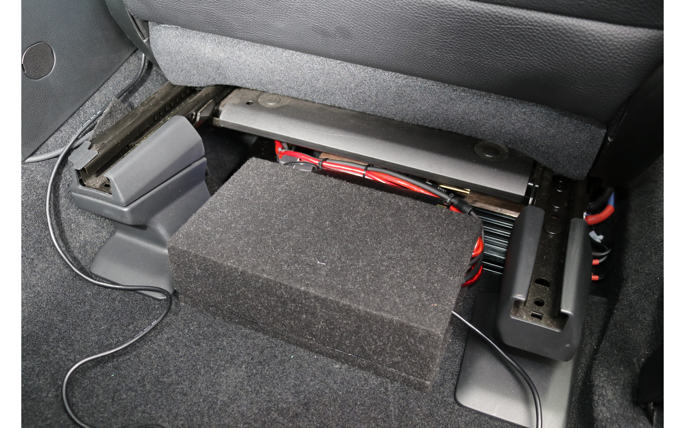 運転席のシート下にはこのようにパワーアンプとDSPをインストール。DSPにはカバーが設けられている。