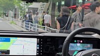 次世代プロパイロットは徐行しながら、わずかに左に切って行列待ちの人を避けて通った。