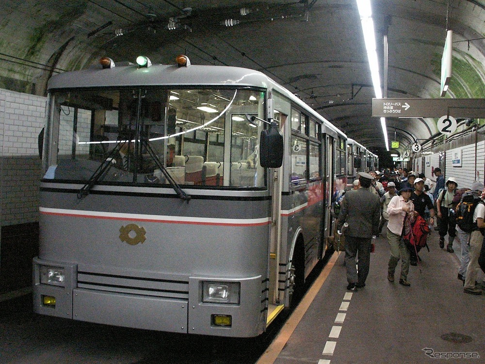 最終便の発駅となる黒部ダム駅で発車を待つ関電トロリーバス。