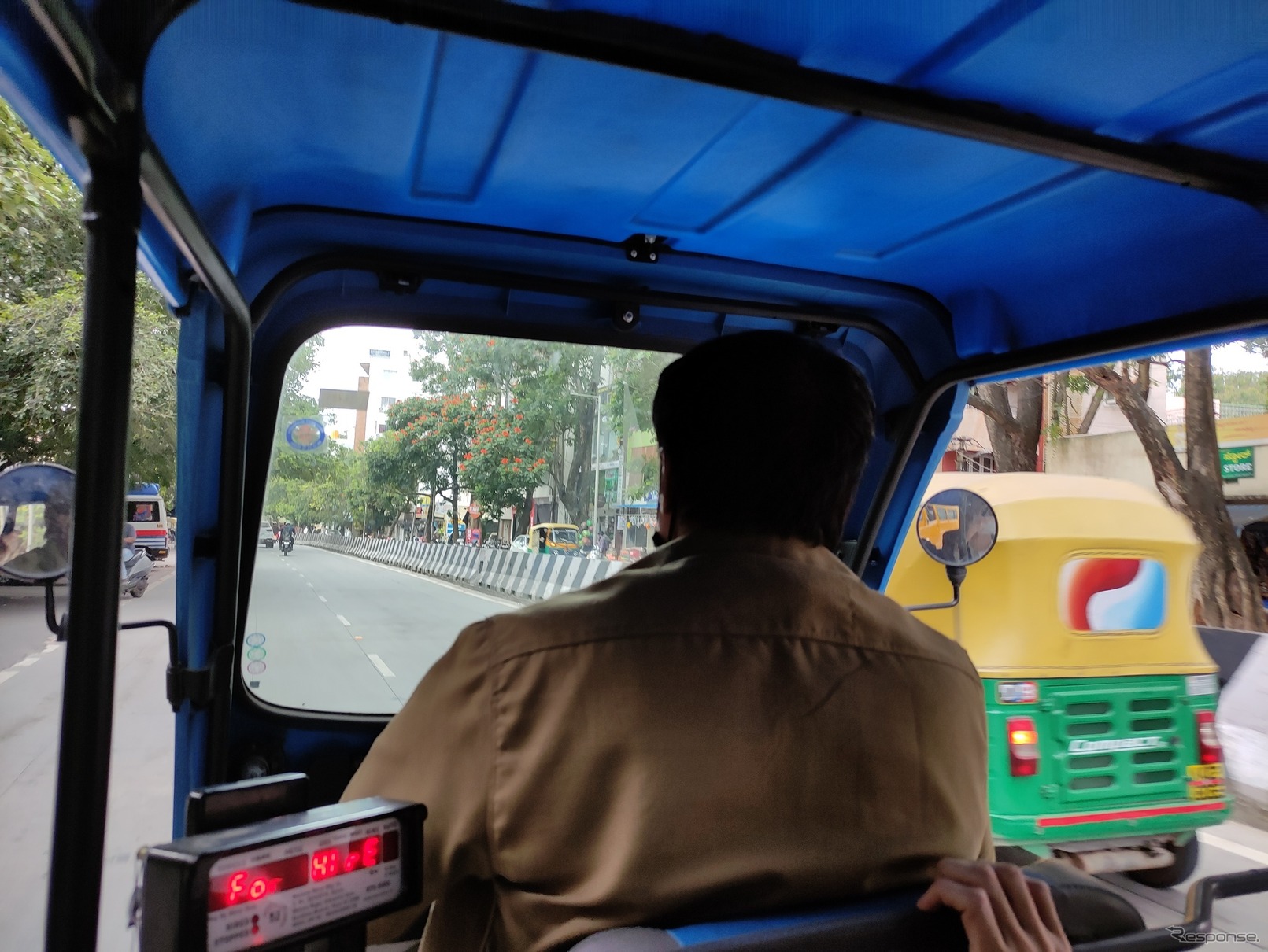 EVリキシャ（電動三輪タクシー）の車内より。並走する「黄色と緑」は内燃機関モデル