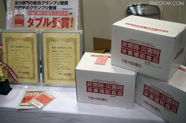 ジオナの「非常時・災害時栄養補給食品」はビタミンとミネラルを補給する備蓄用粉末食品。東京都の自治体や病院などでも備蓄品として採用されている。保存期間は5年間。一箱で50人/一週間分となっている（撮影：防犯システム取材班）