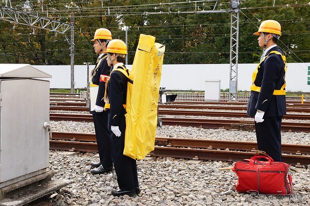 列車からの非常脱出に使うハシゴは駅に常備されており、職員が背負って運ぶ。
