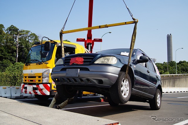 段差に乗り上げた車両はユニック車で撤去。この後、ロープ牽引で移動させた。