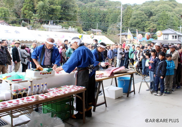 新鮮なマグロの刺し身を無料で食べられるとあって、長蛇の列ができていた