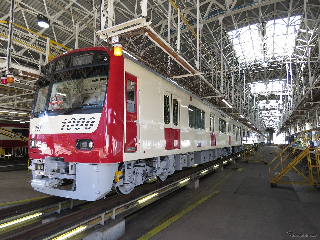 京急ファインテック久里浜事業所に搬入された第1201編成。先頭部は赤白2色の塗装が完了している。