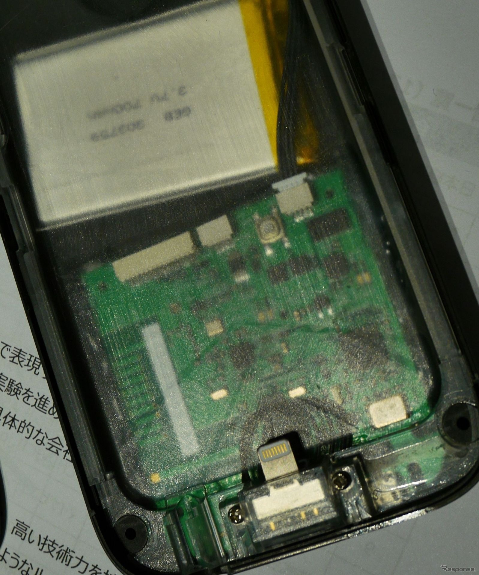 スマートフォンケースの内側に、スマートフォンと接続するプラグが見える。上部に見える白い部品はバッテリー。スマートフォンケース側のUSBから、スマートフォン本体と同時に充電する仕組み。