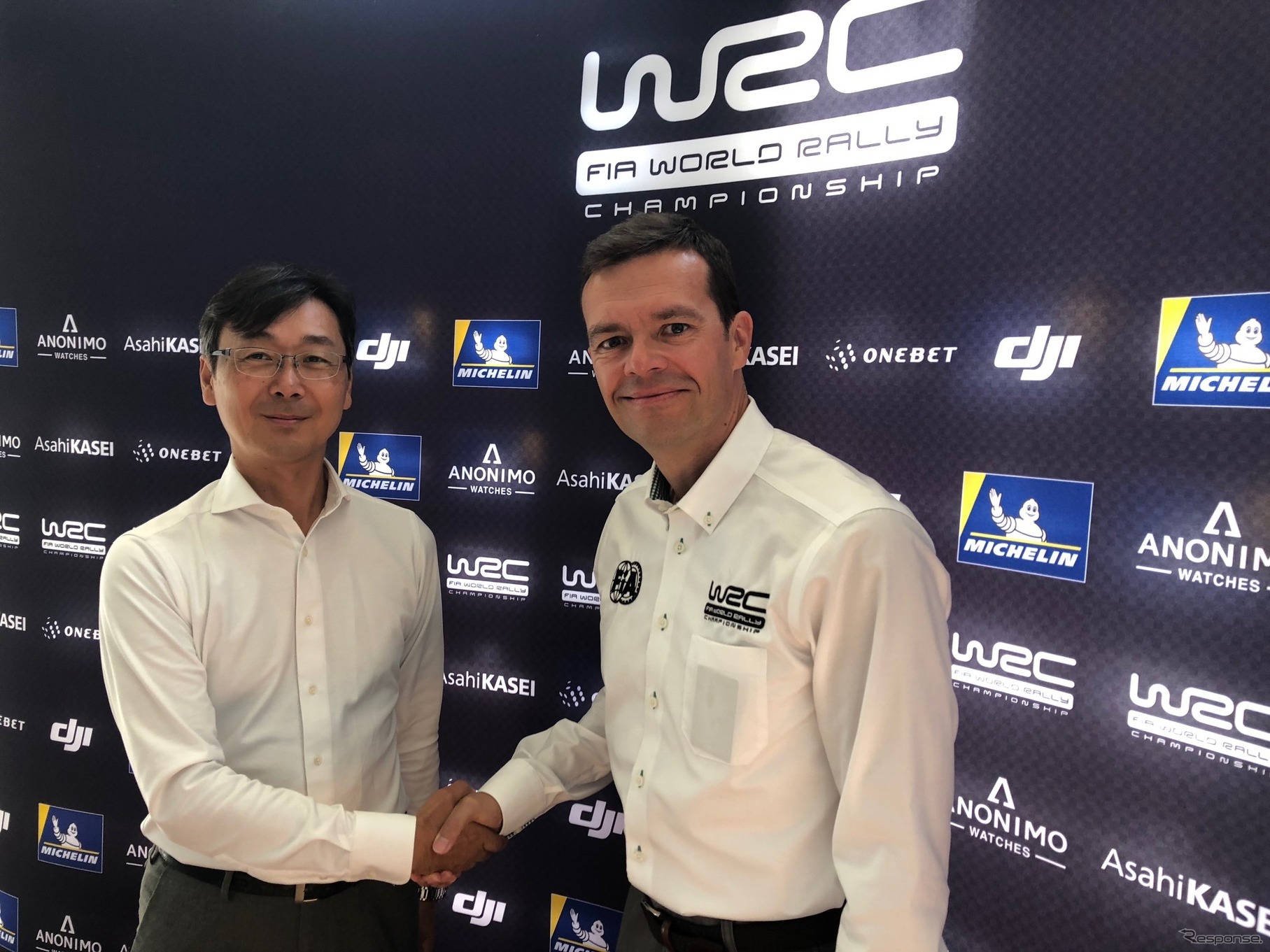 高橋氏とWRCプロモーター代表のO.シースラ氏（シースラ氏はビデオメッセージでの報告会参加）。
