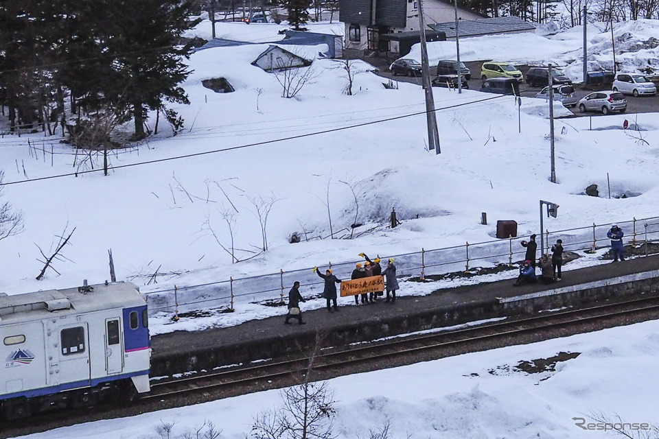 鹿ノ谷駅で横断幕を掲げ、新夕張行きの発車を見送る地元の人々。2019年3月31日撮影。