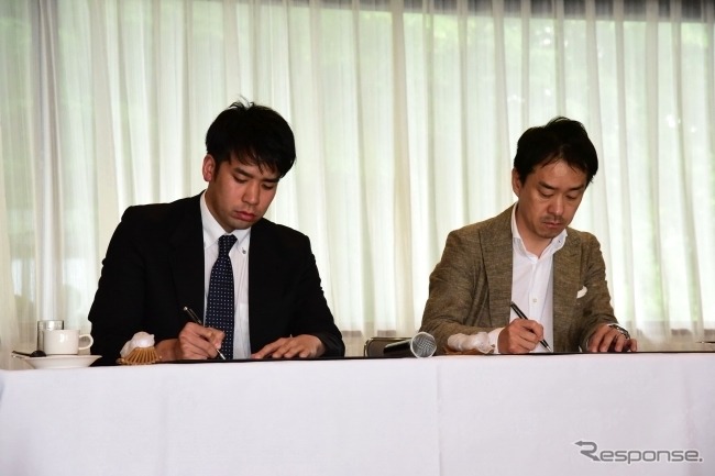 実証実験に関する合意書の調印式の様子。Azitの須藤信一朗取締役（左）、那須高原次世代交通協議会の片岡孝夫会長