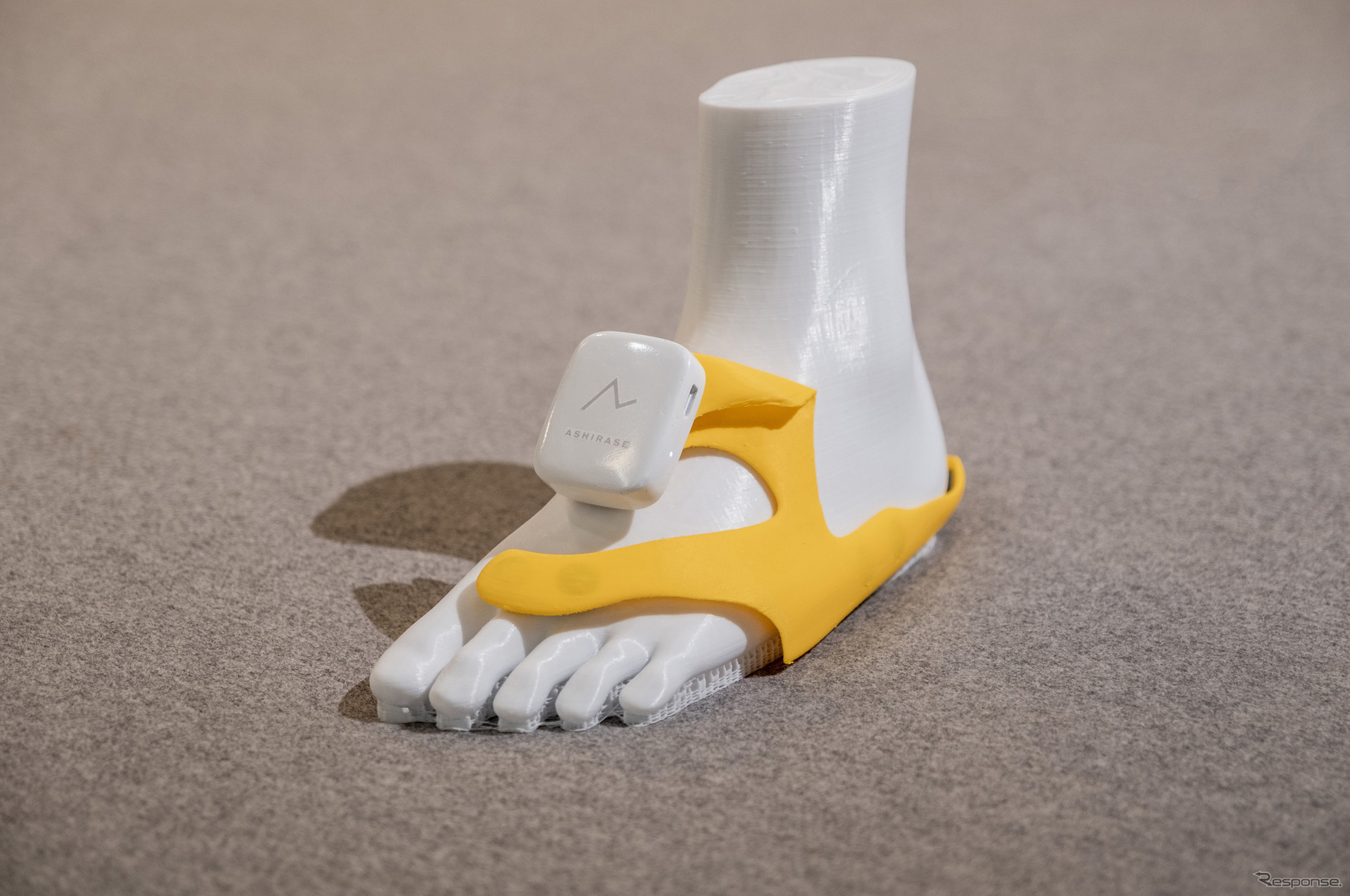 「あしらせ」のデバイス。黄色の部分は靴の中に取り付ける立体型のモーションセンサー付き振動デバイスになっている。