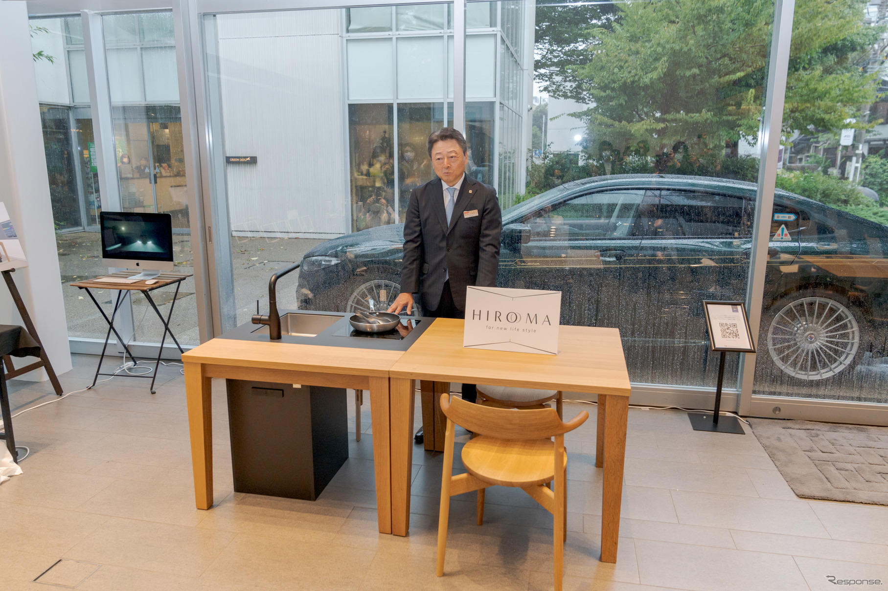 HIROMAと代表取締役社長執行役員・竹内宏氏の後ろには、BMW ALPINA B8 Gran Coupéが展示されている。