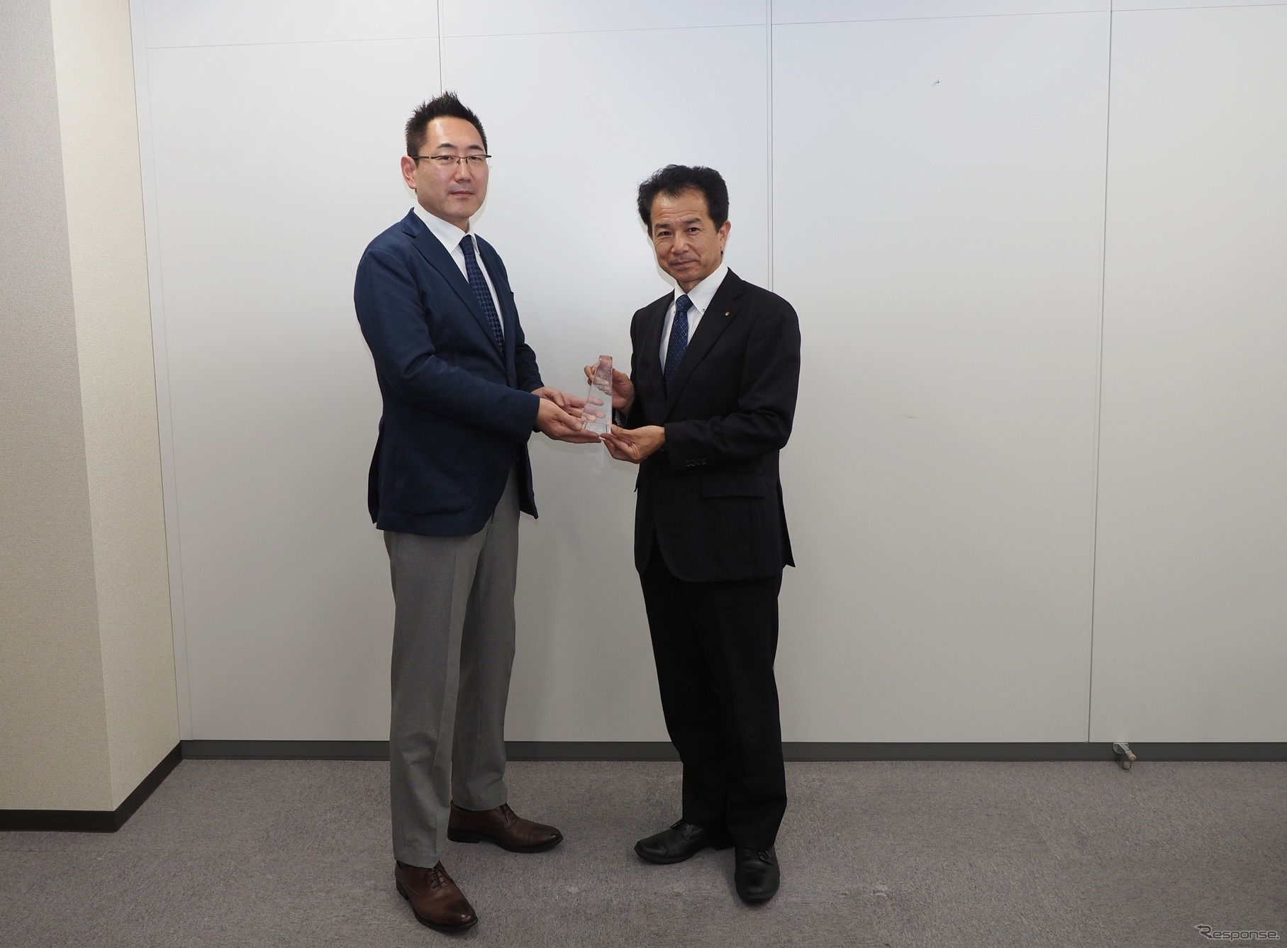 米澤チーフエンジニアにトロフィーを手渡す三浦選考委員長（左）