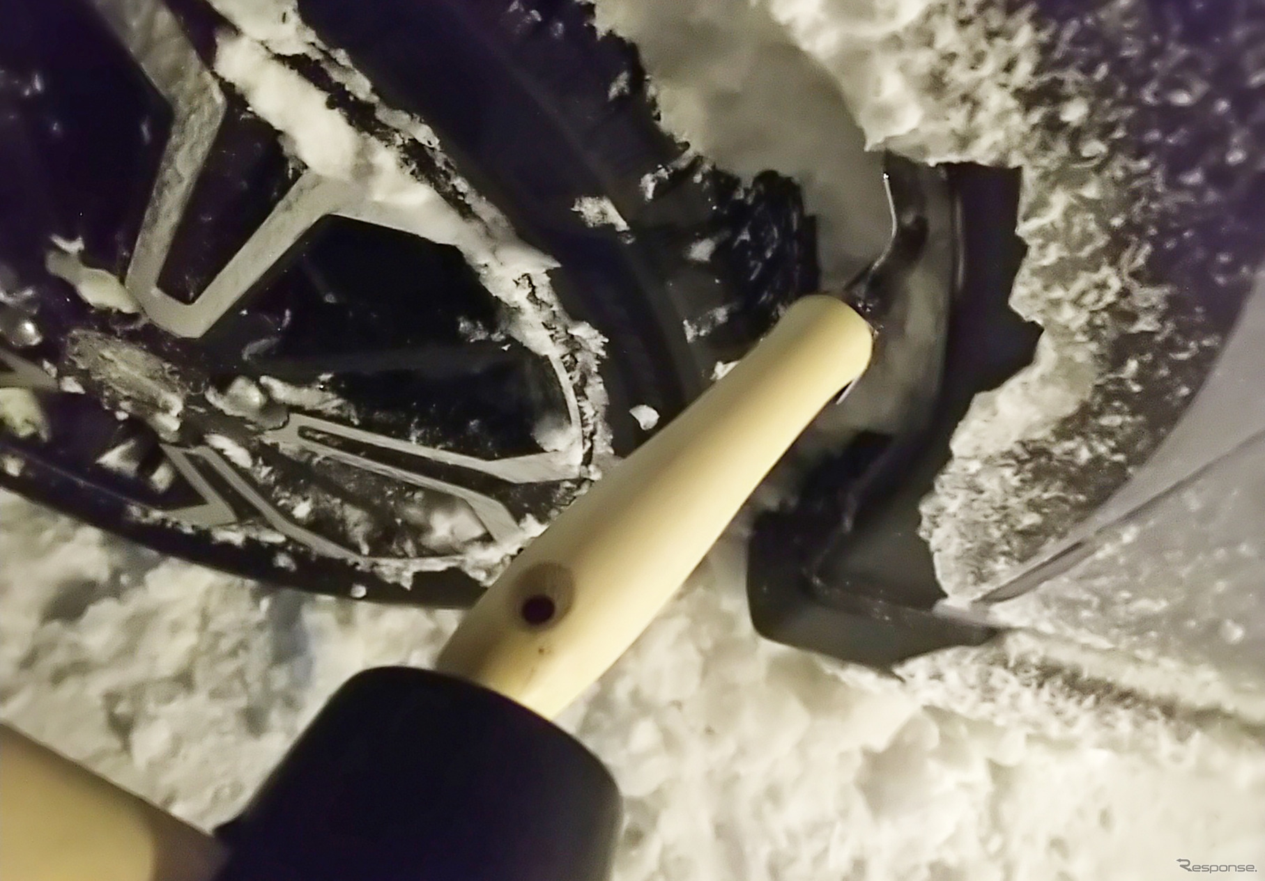 三菱 eKクロスEV 冬季1200km試乗前編：着氷を放置していると前輪の舵角を確保できなくなるので、適宜落とす必要がある。スコップの把手をゴムハンマーで叩いて氷を割るが効率が悪い。探せばおそらくげんのうのような、もっと便利な道具があると思う。