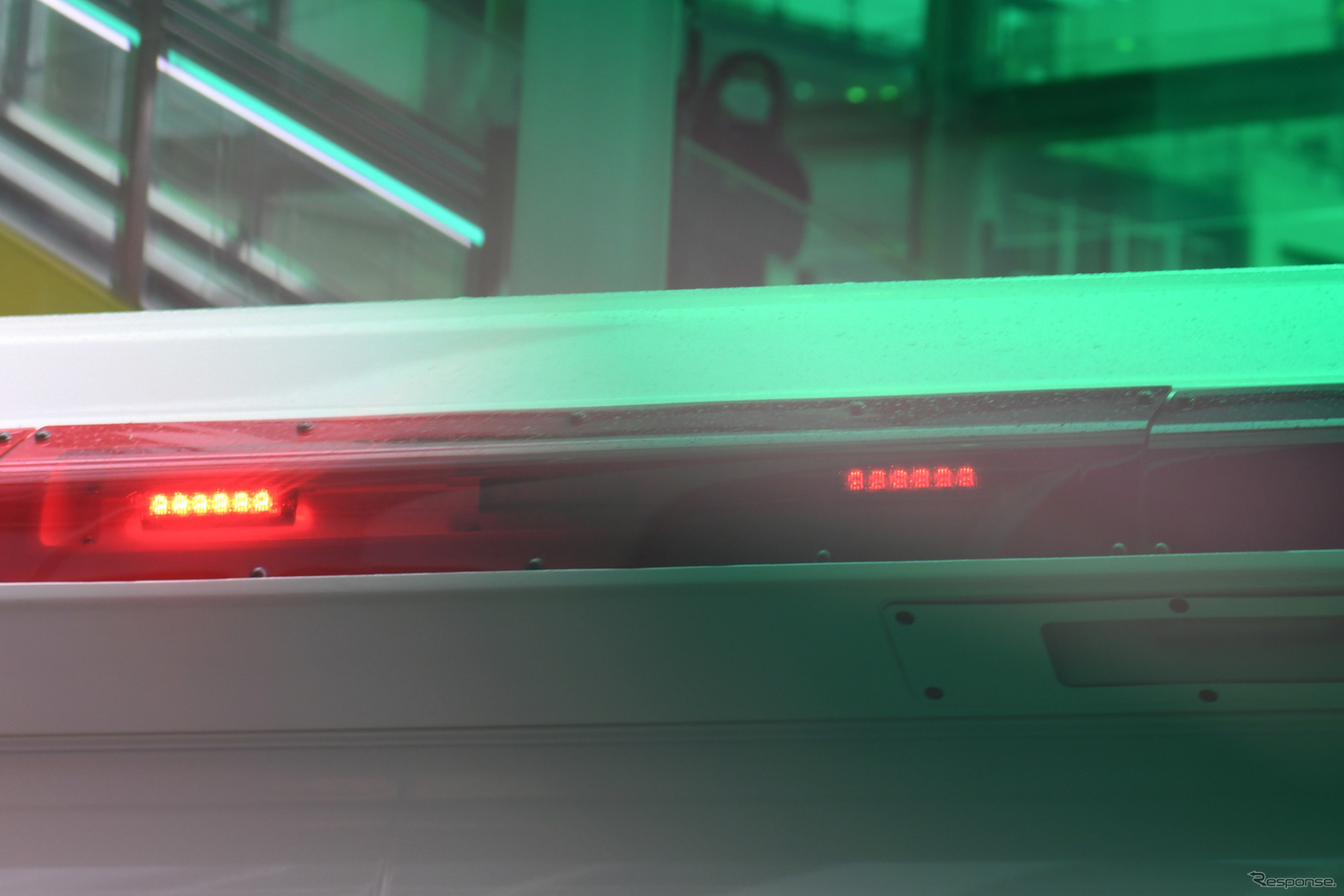 弱視体験ゴーグル越しに見た赤色灯（右側）。カメラでは緑がかって写るが、実際は赤い以外は普通に見える。赤がくすんだ暗い海老茶（葡萄茶）色に見えるだけでなく、赤色灯はLED光源のシルエットがわかる程度になる