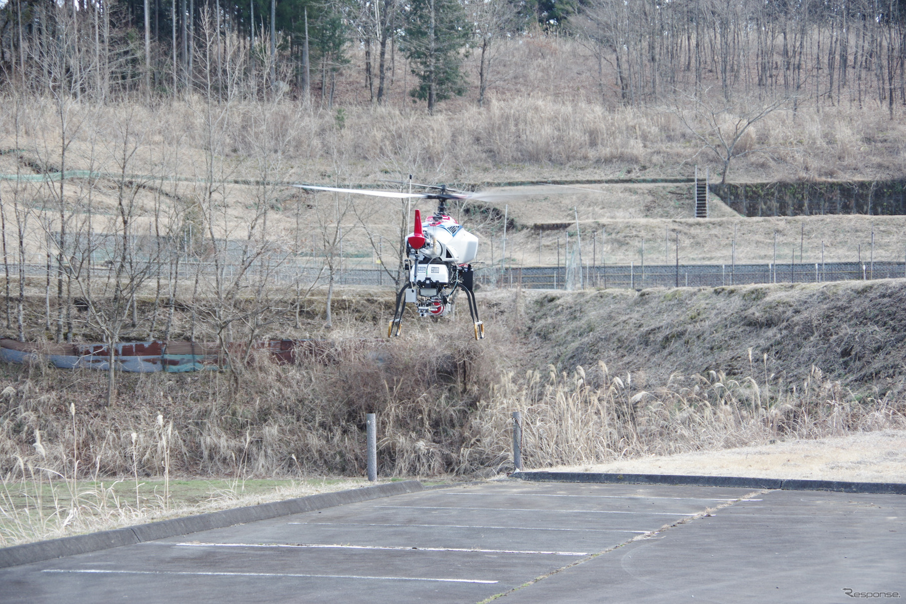 バイクのようなエンジン音とともに産業用無人ヘリコプターが離陸する瞬間。