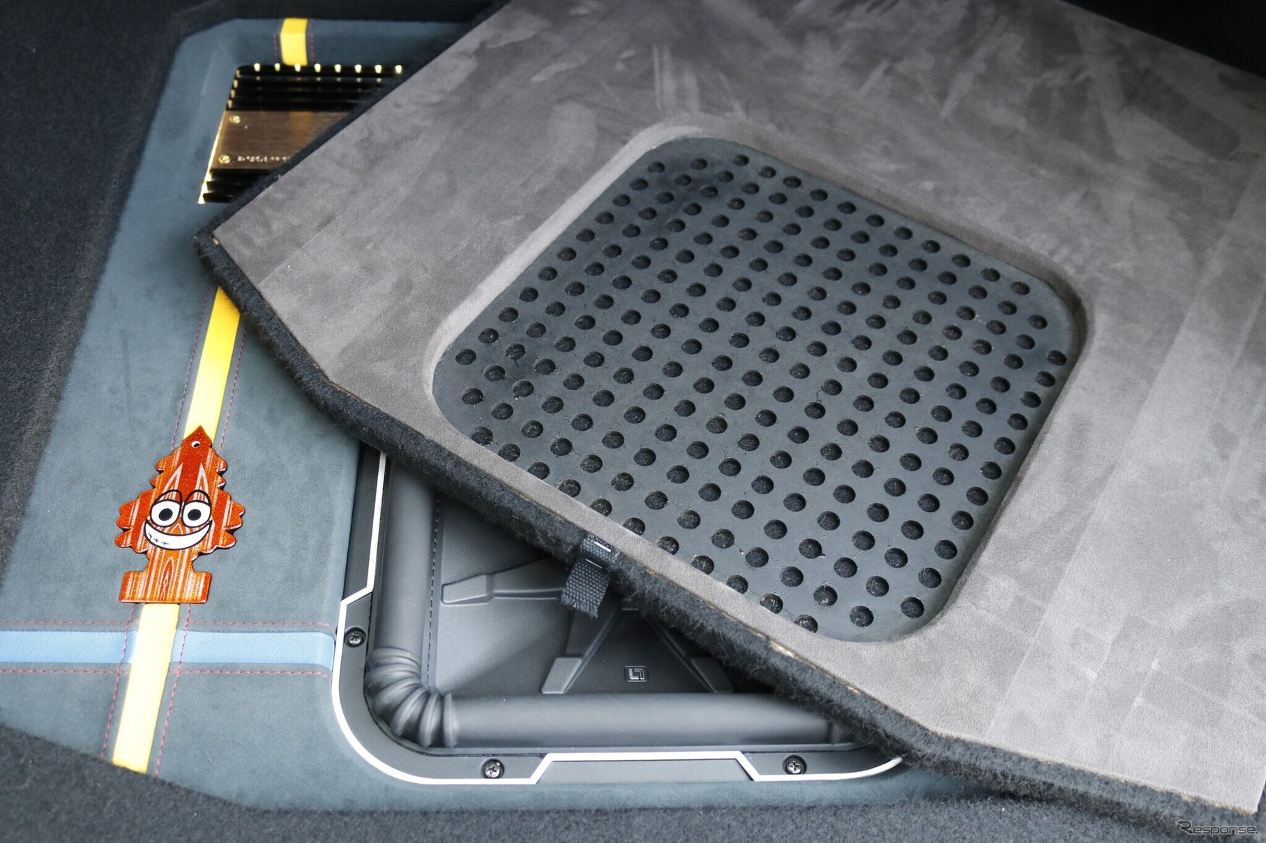 ラゲッジの中央部をカバーするプロテクションボードはサブウーファー部分に音抜け用の処理が施されている。