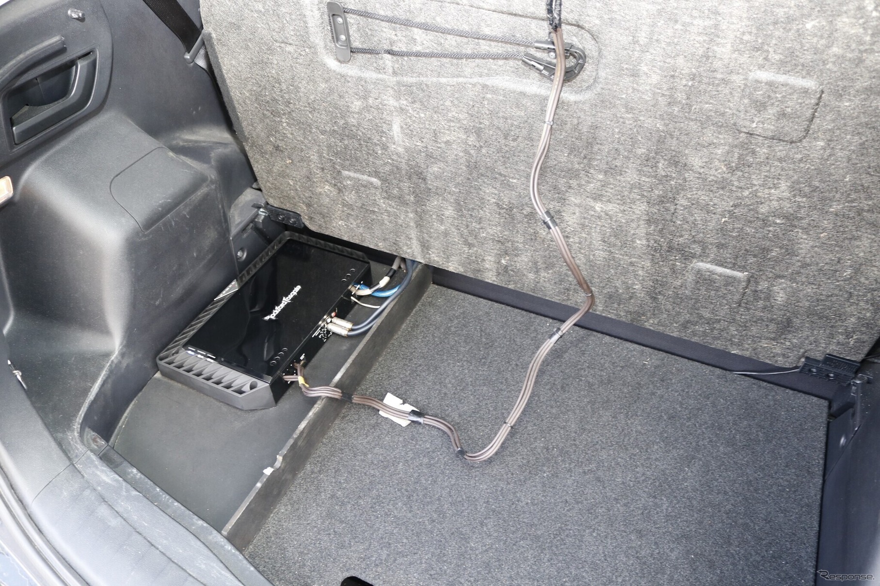 ラゲッジフロアの表面のパネルを跳ね上げると見えてくるのがサブウーファー用のパワーアンプT1500-1bd。