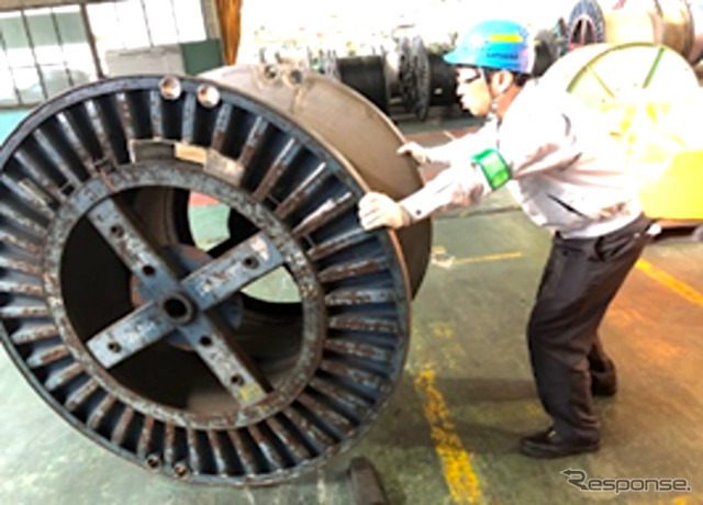 人力での電線ドラムの搬送の様子