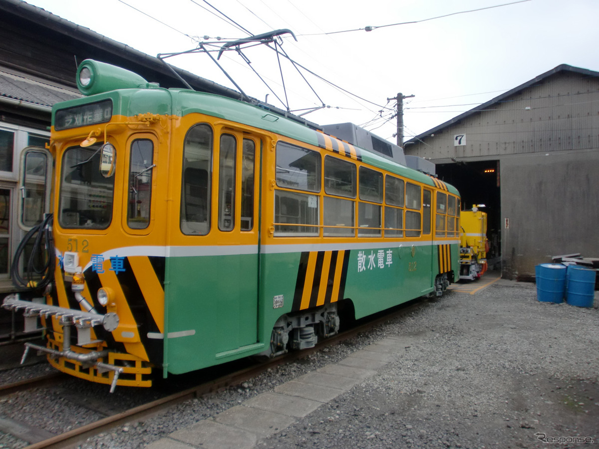 旧式の500型車両を改造した散水車が芝刈り電車を牽引する