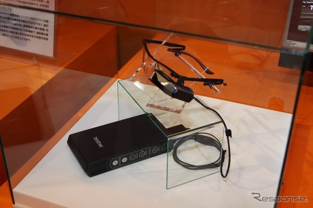 ブラザー工業のメガネ型網膜走査ディスプレイ。メガネの左側の小さな機械が網膜に映像を投影