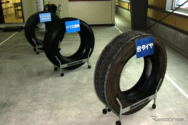 手前からリトレッドの台タイヤ（磨り減ったタイヤ）、トレッドゴムを削り取ったバフ工程後のタイヤ、クッションゴム貼り付け後のタイヤ。