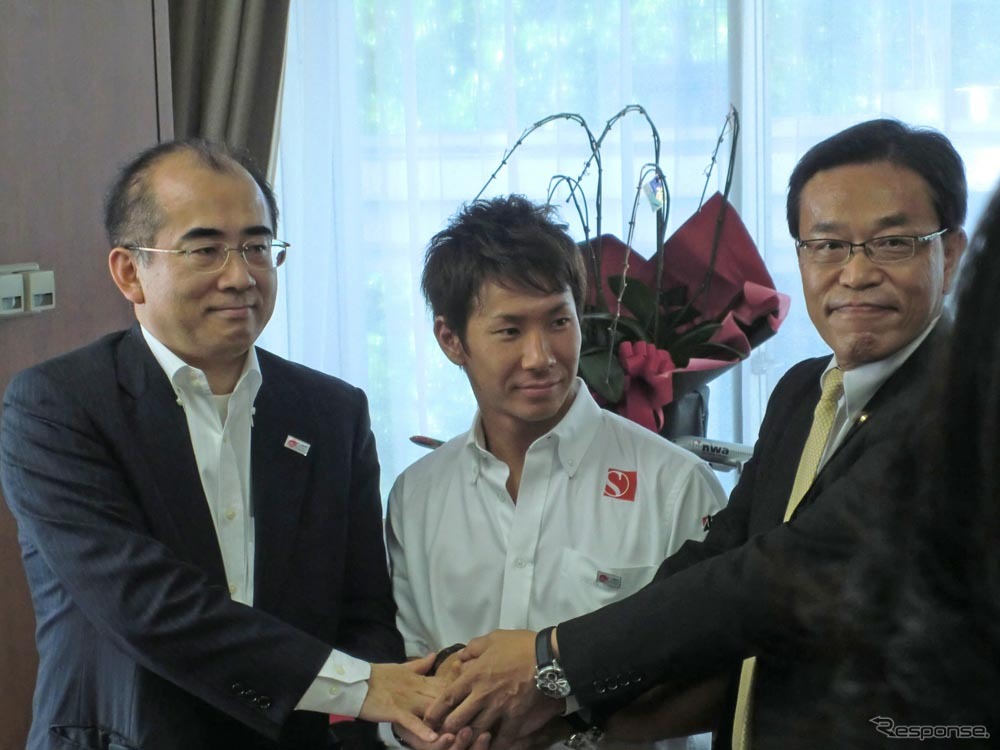 溝畑宏観光庁長官（左）らと握手する小林可夢偉（中央）